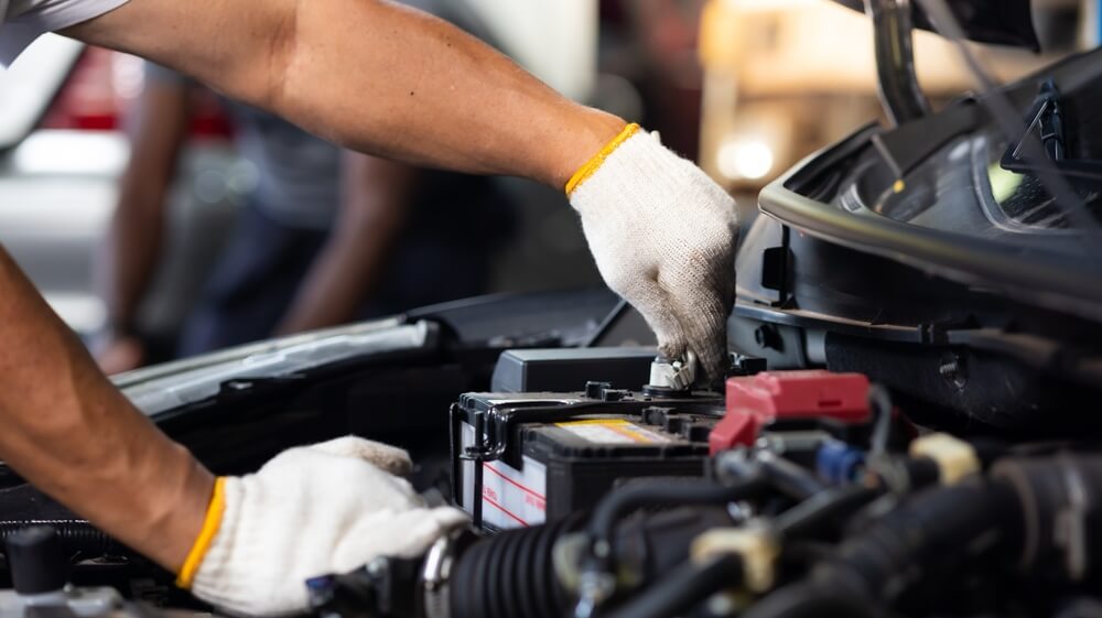 Technician testing and replacing a car battery in Tulsa, OK